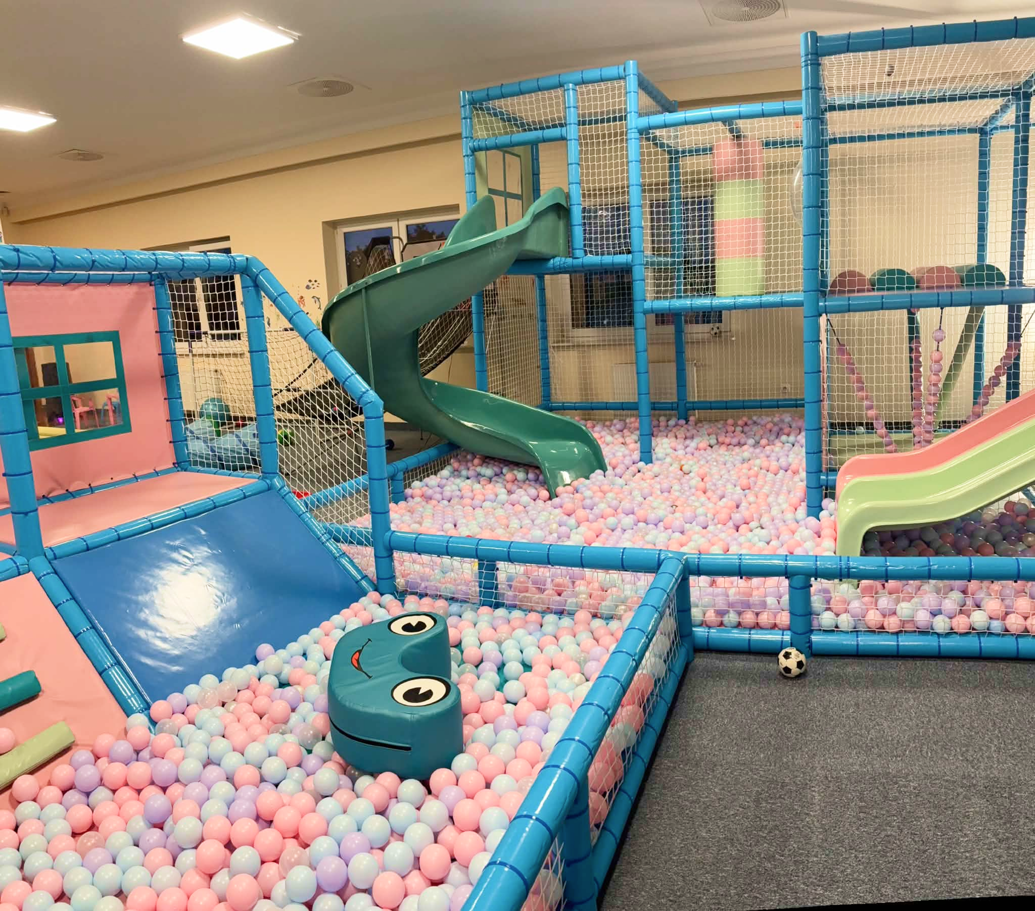 Dziecko wspinające się po miękkiej, kolorowej konstrukcji do zabawy